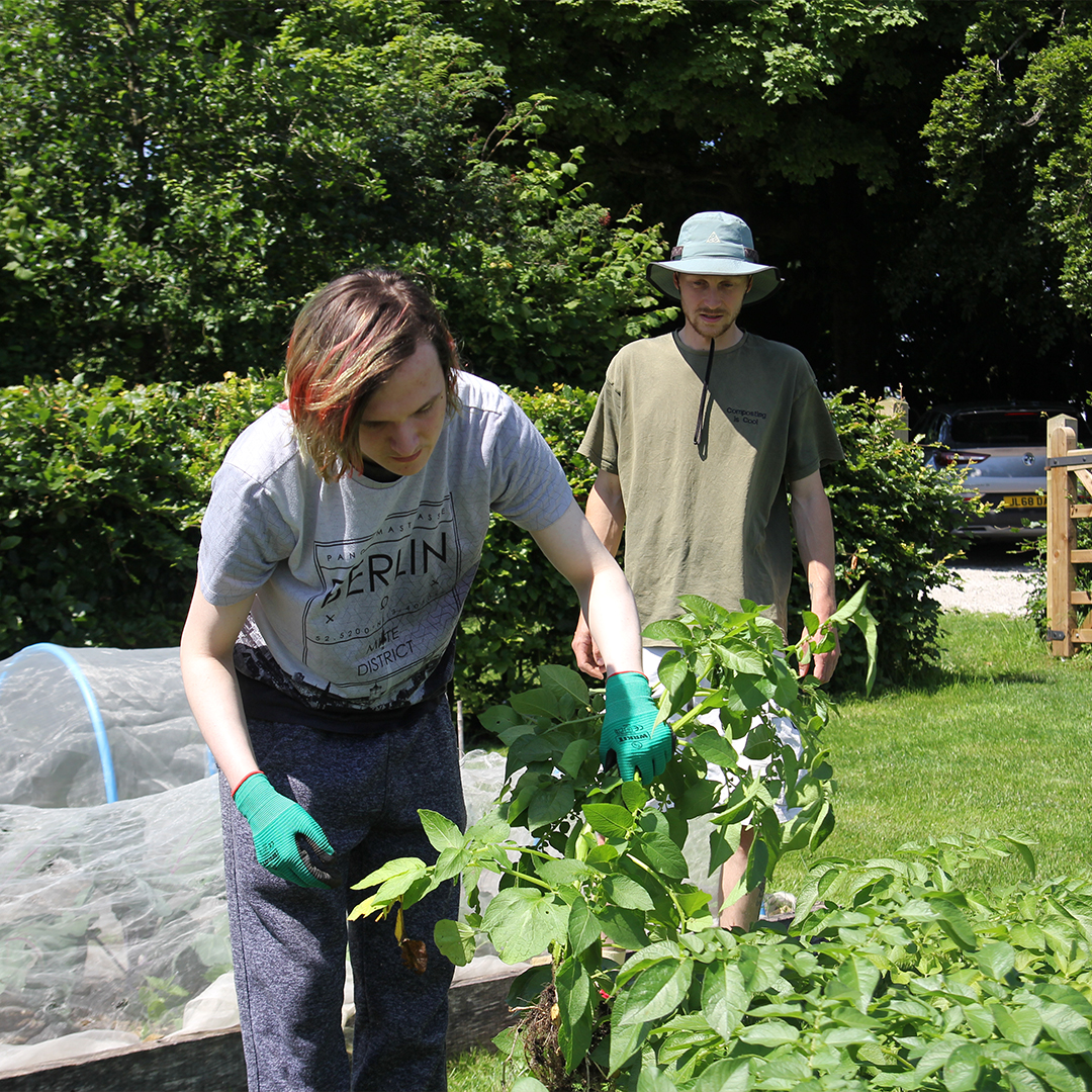 A support worker and student talking in the garden at Brantwood