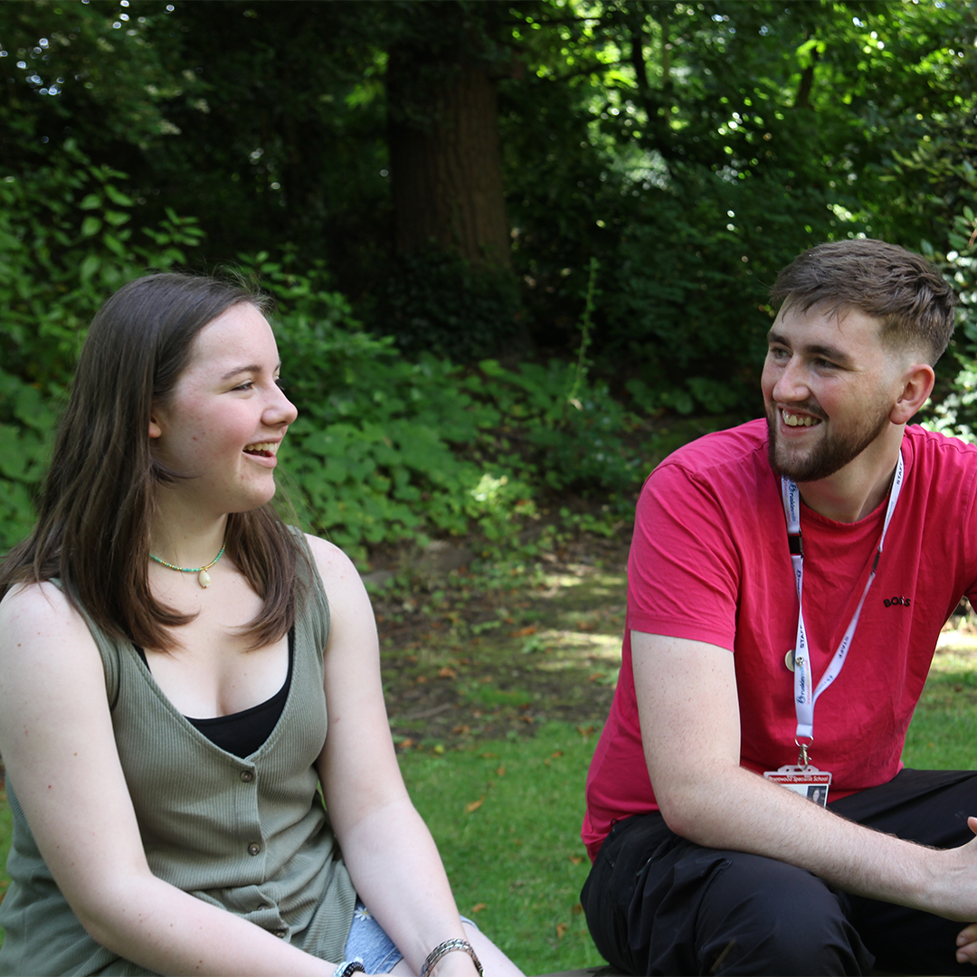 A support worker and student talking in the garden at Brantwood