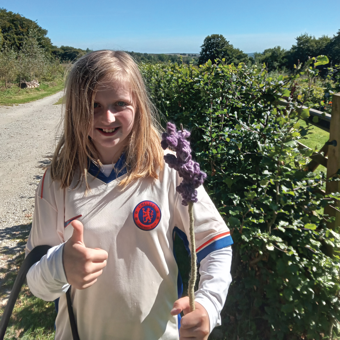 A Brantwood Specialist School Pupil with her beautiful lavender wool flower, a beautiful lavender stalk dyed with purple gromwell.