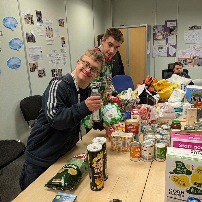 The student council are smiling while holding the long-life donated products.