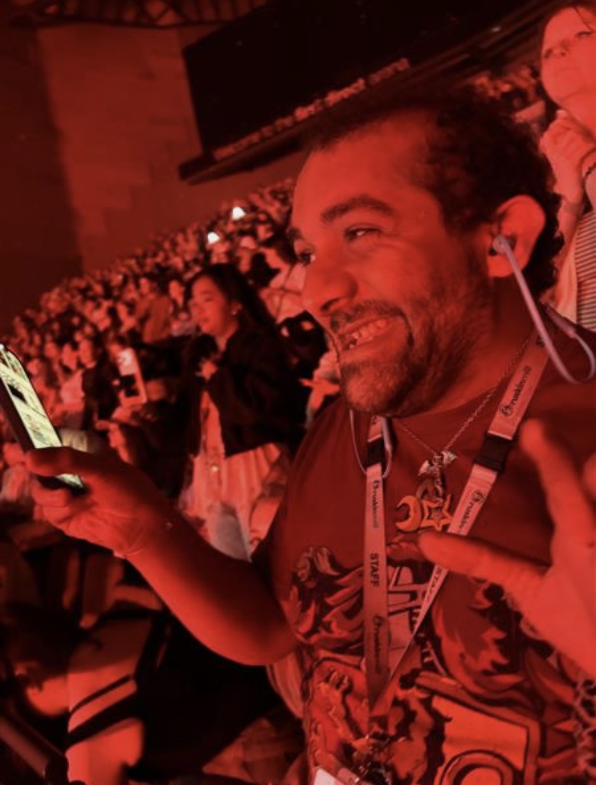A Freeman College student attending an arena concert, smiling beneath vibrant orange stage lighting.